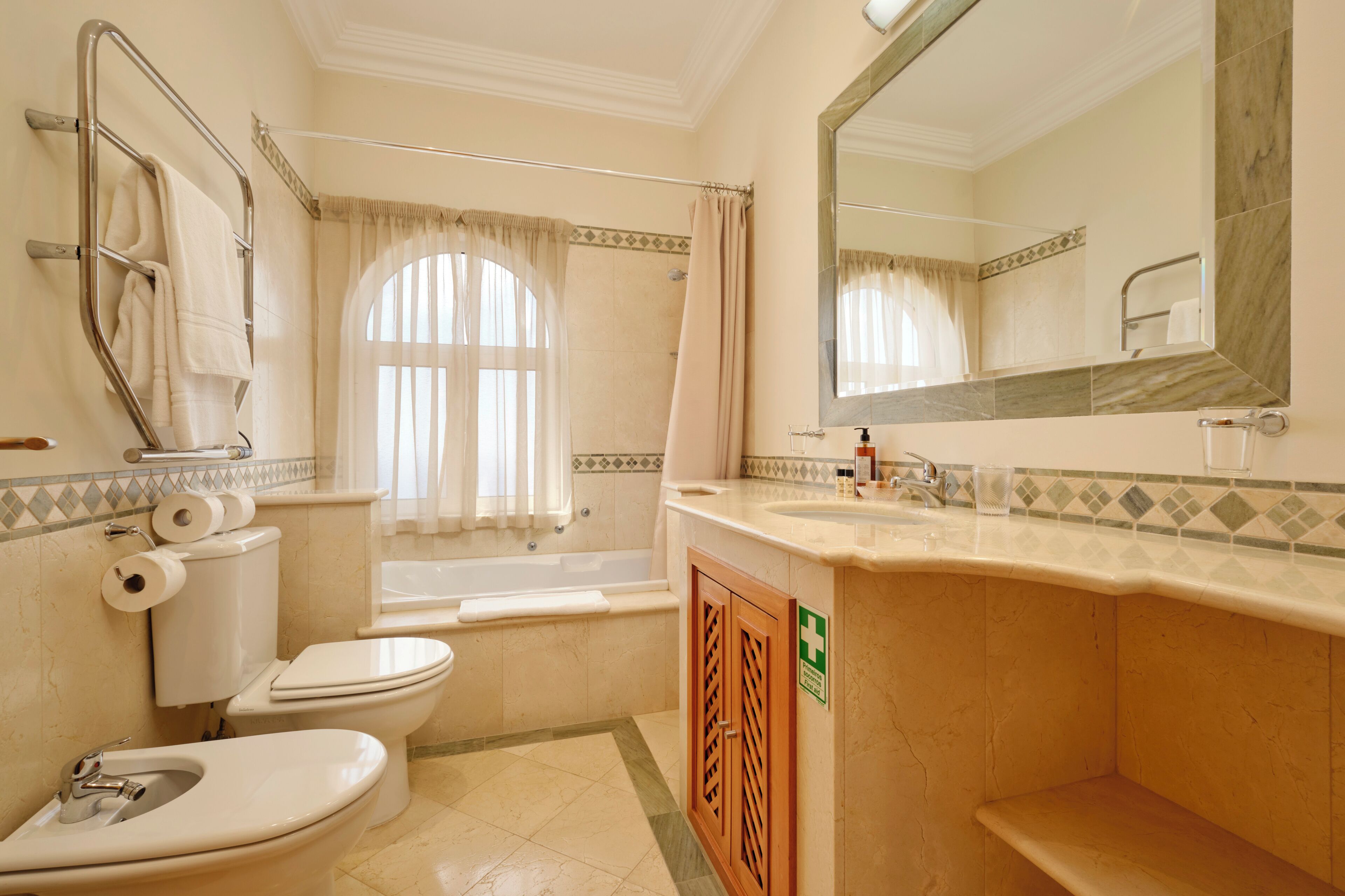 Ein Badezimmer mit Toilette, Bidet, Waschbecken und Badewanne.