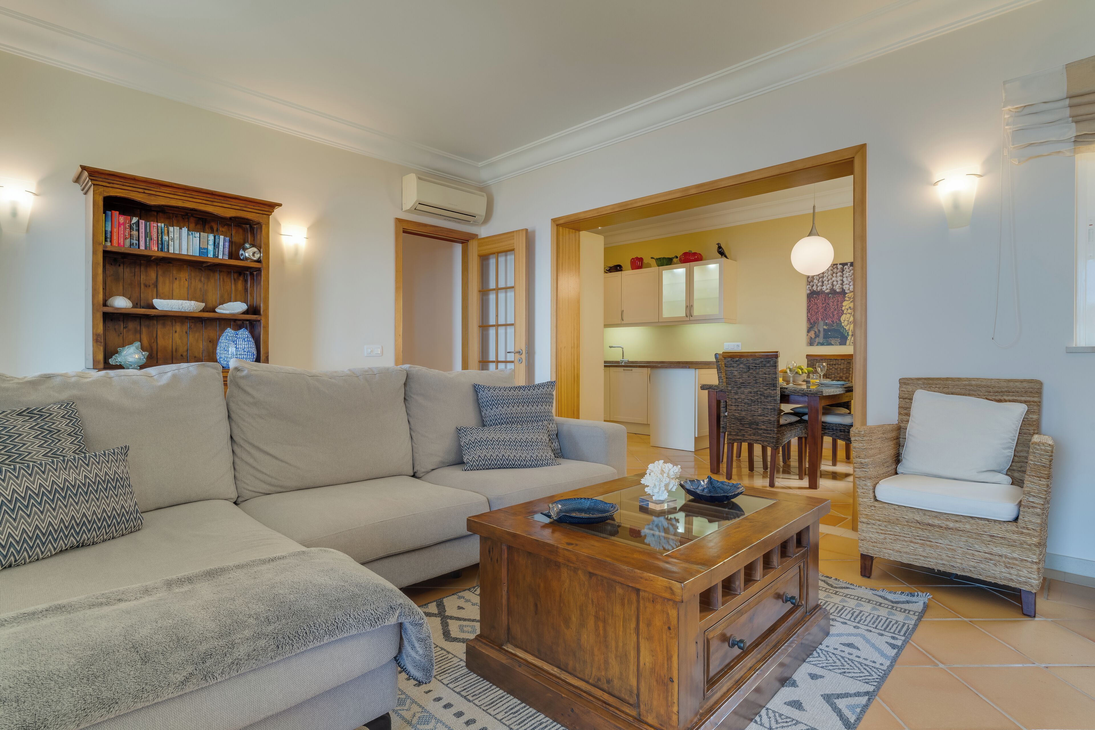 A living room with a sofa, coffee table, and a bookshelf.