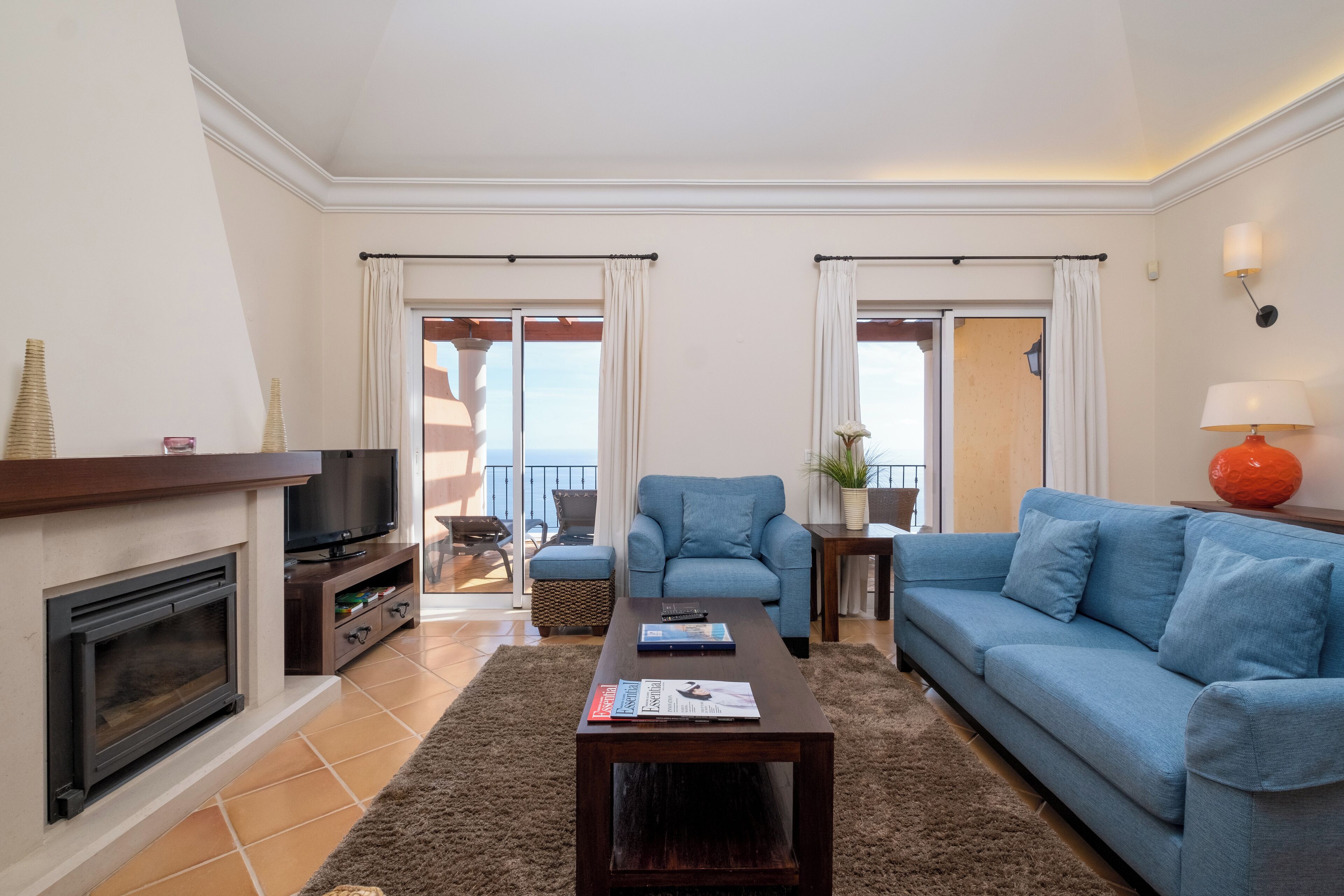 A living room with a fireplace, a sofa, a coffee table, and a television.
