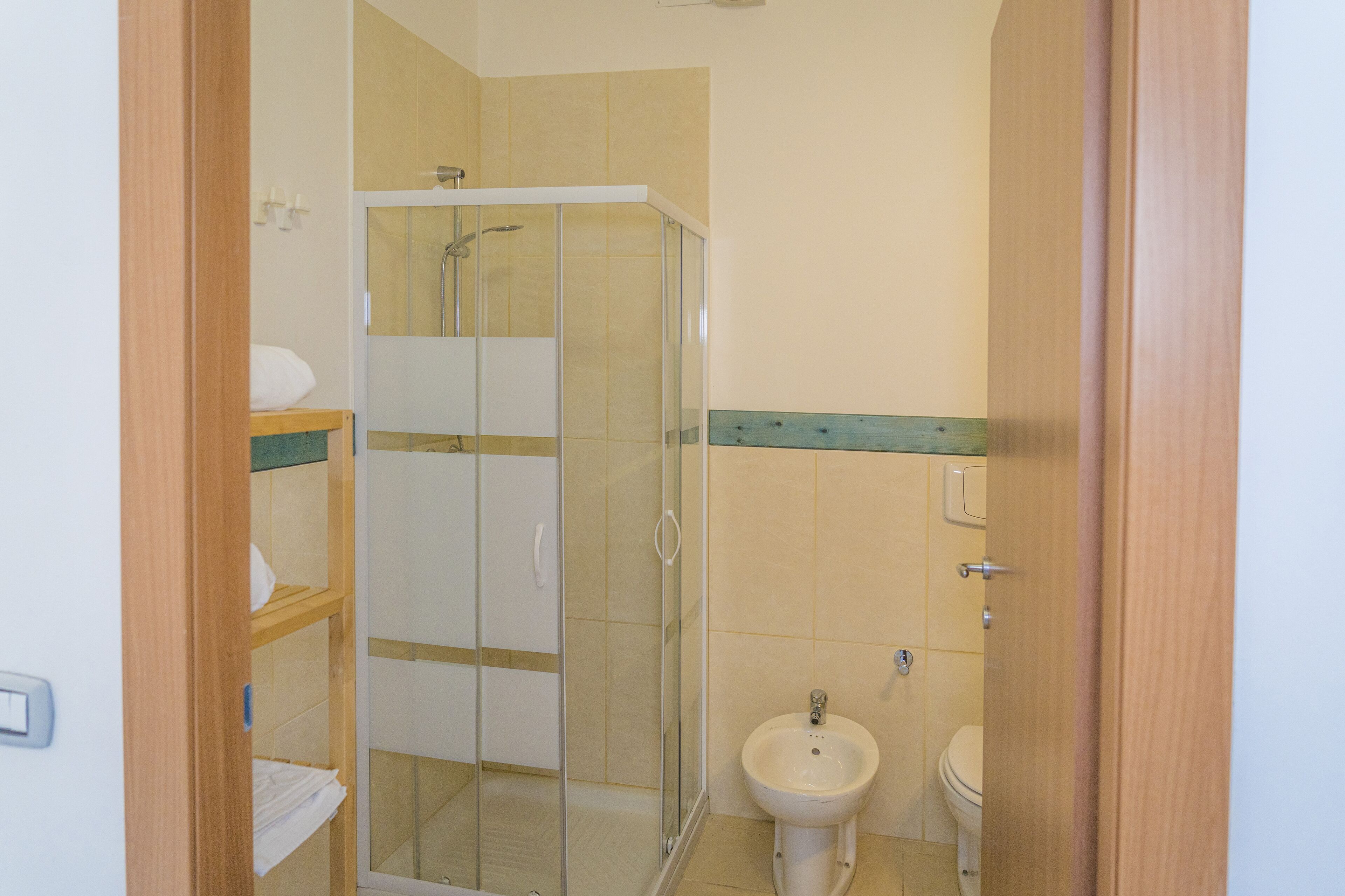 A bathroom with a glass shower enclosure, a sink, and a toilet.