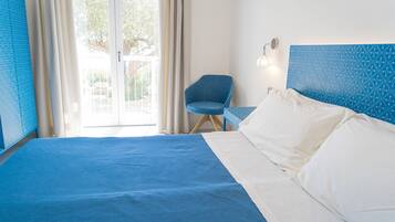 Une chambre d’hôtel avec un grand lit, une chaise et une vue sur l’extérieur grâce à une porte vitrée.