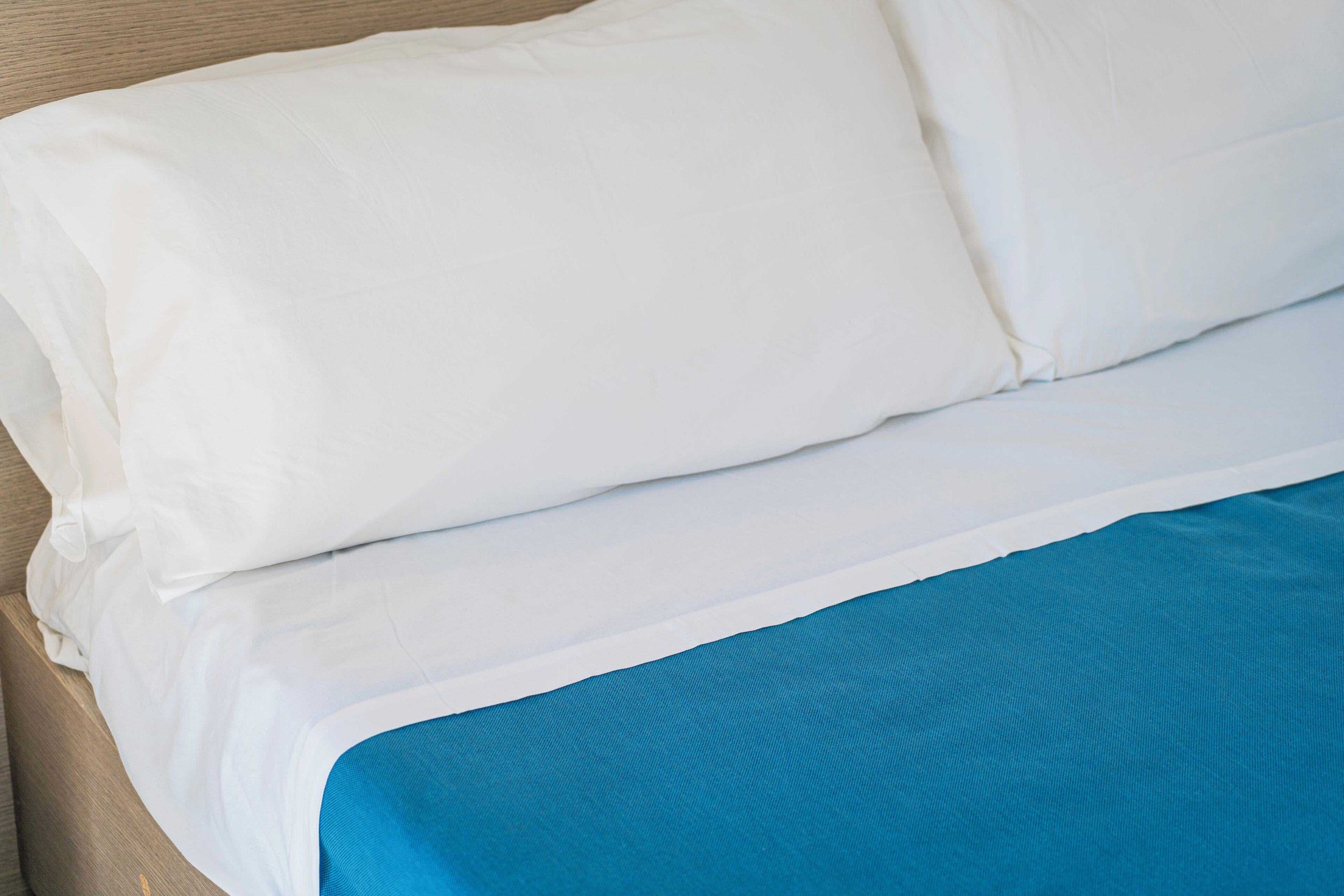 A bed with white and blue bedding.