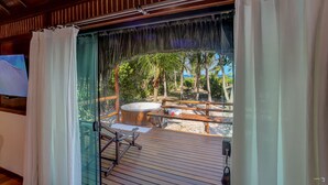 A wooden deck with a hot tub, a wooden bench, and a glass door leading to a beach view. - Aldeia da Mata Eco Lodge (Uruçuca)