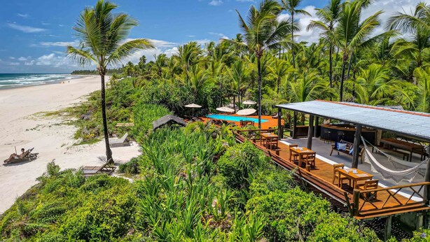 A beachside resort with a pool, wooden deck, and lounge chairs. - Aldeia da Mata Eco Lodge (Uruçuca)