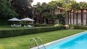 Una piscina al aire libre, sillones reclinables de piscina