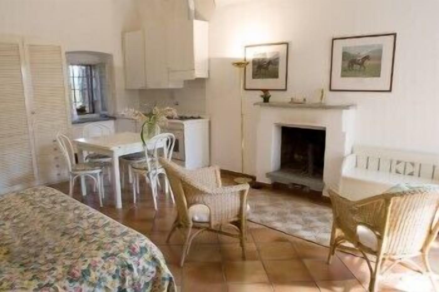 Una habitación acogedora con una mesa de comedor, sillas, un sofá y una chimenea.