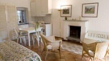 Una habitación acogedora con una mesa de comedor, sillas, un sofá y una chimenea.