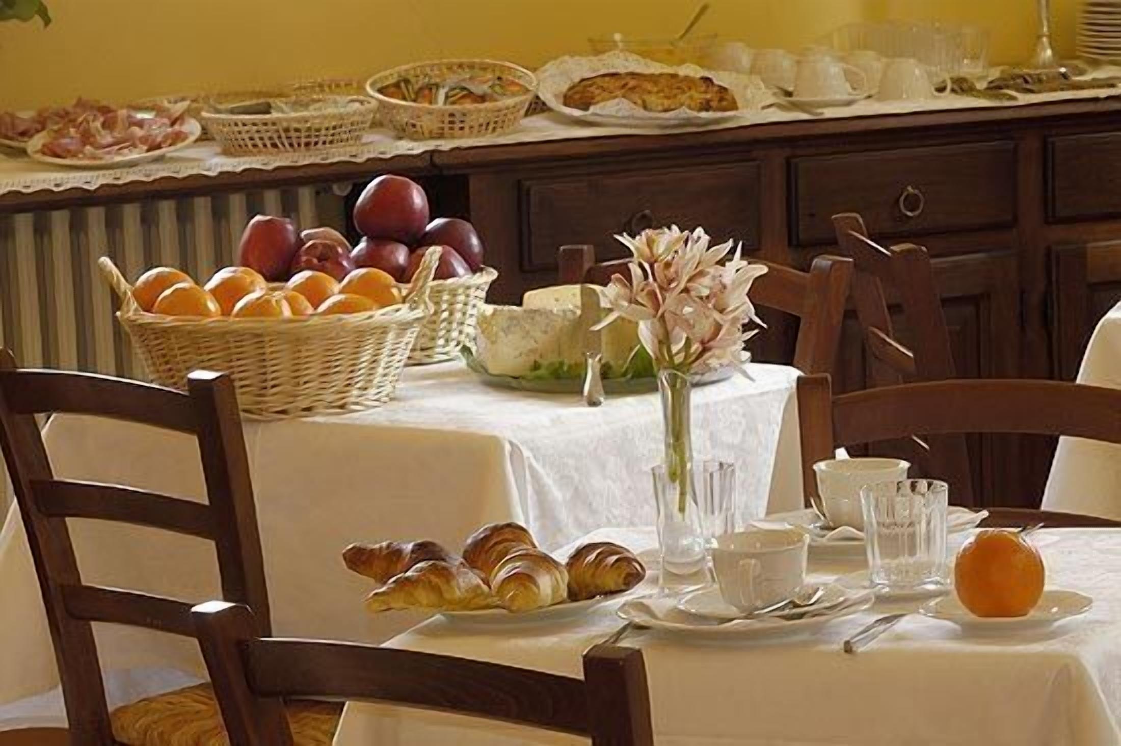 Ein Frühstückstisch mit Croissants, Obst und Käse.