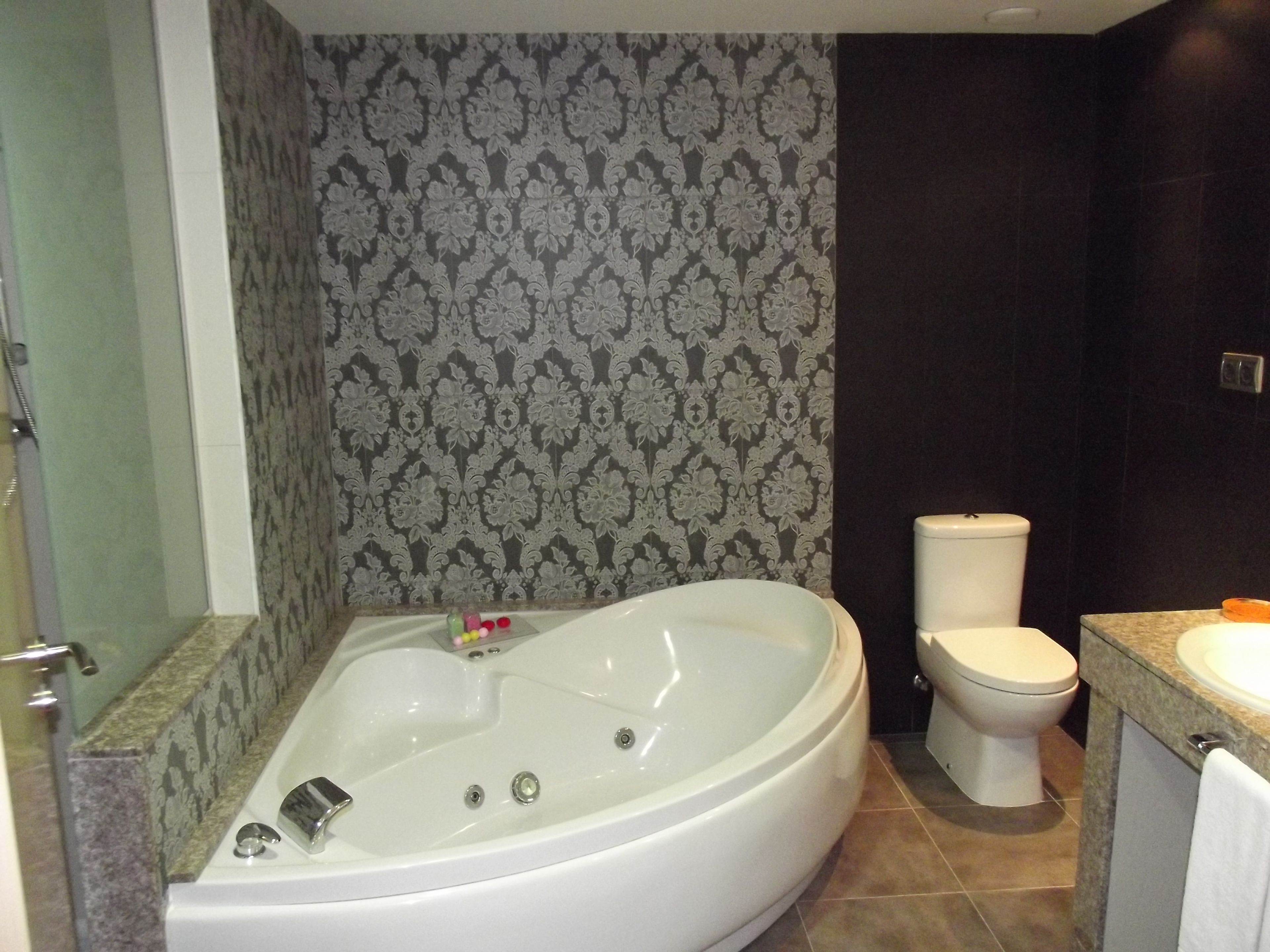 A bathroom with a freestanding bathtub, a toilet, and a sink.