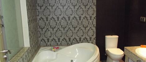 A bathroom with a freestanding bathtub, a toilet, and a sink.