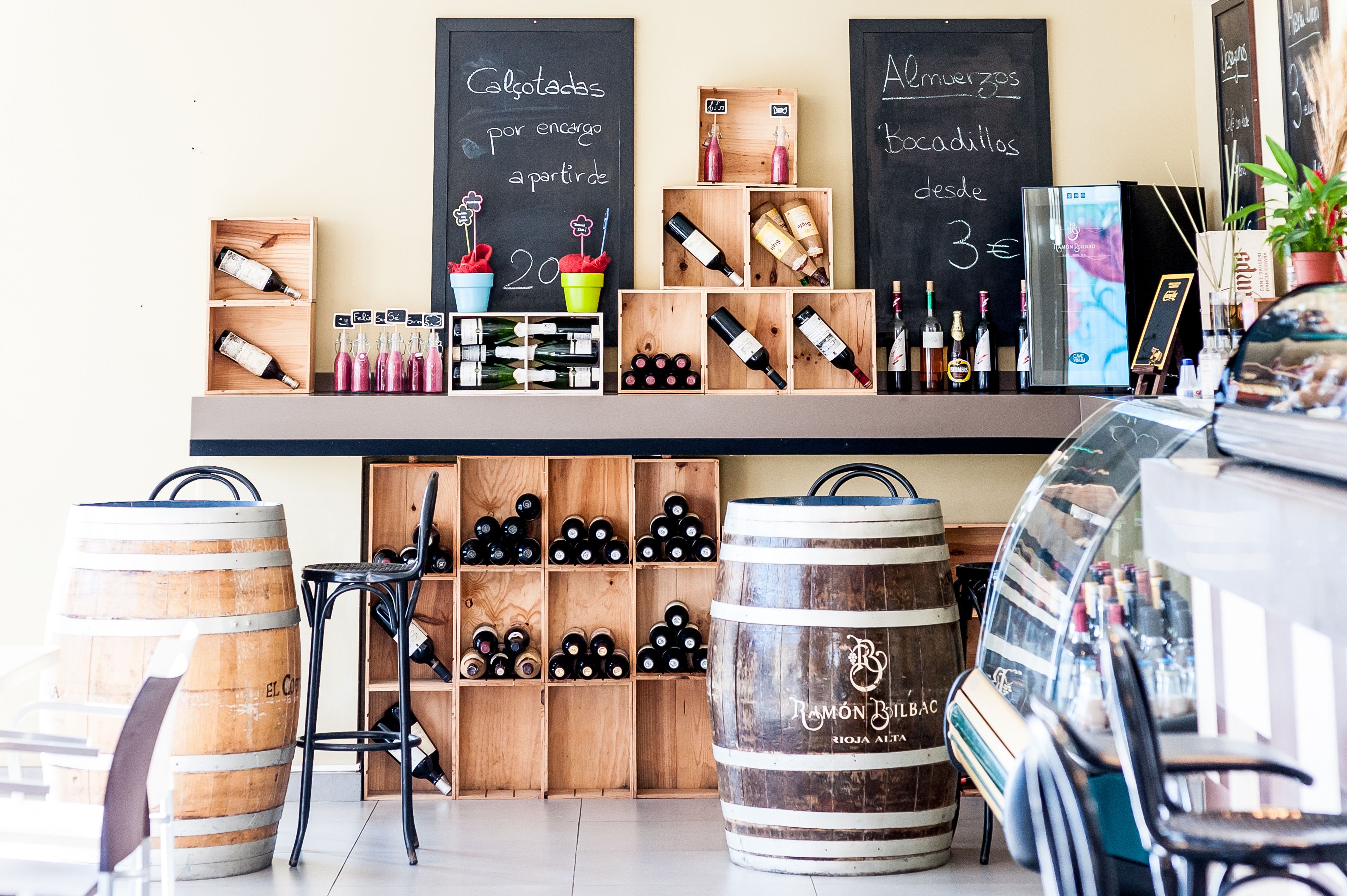 A wine shop with wooden shelves displaying various bottles and a chalkboard menu.