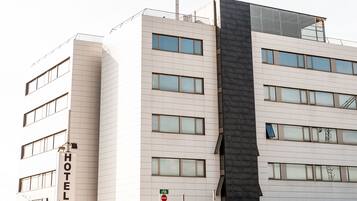 A hotel with a modern facade, multiple windows, and a prominent 'HOTEL' sign.