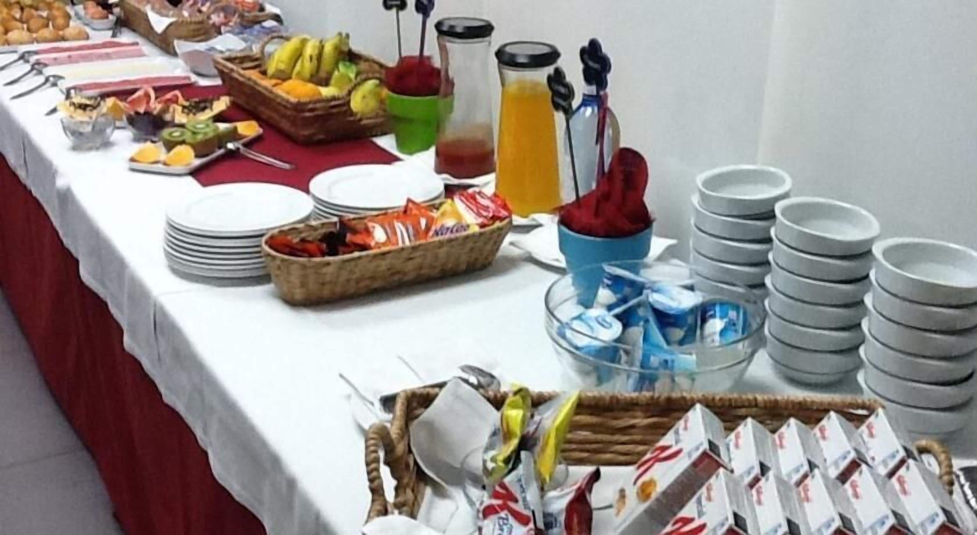 Une table de buffet proposant une variété d’aliments, notamment des fruits, des légumes et des boissons.