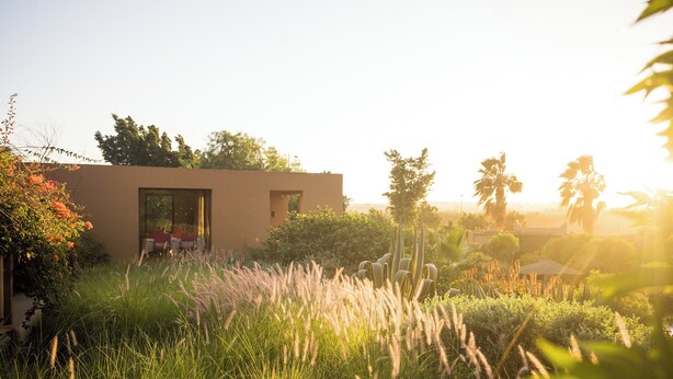 A modern building with a glass door and a small patio area. - Dar Maktoub (Inezgane)