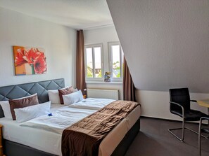 A hotel room with a bed, a desk, and a chair. - KURHOTEL Bad Suderode (Quedlinburg)