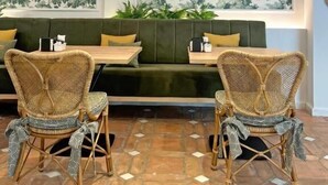 A cozy seating area with wicker chairs and a green sofa, a patterned wall, and a ceiling with recessed lighting. -  Hotel Bestprice Córdoba (Córdoba)