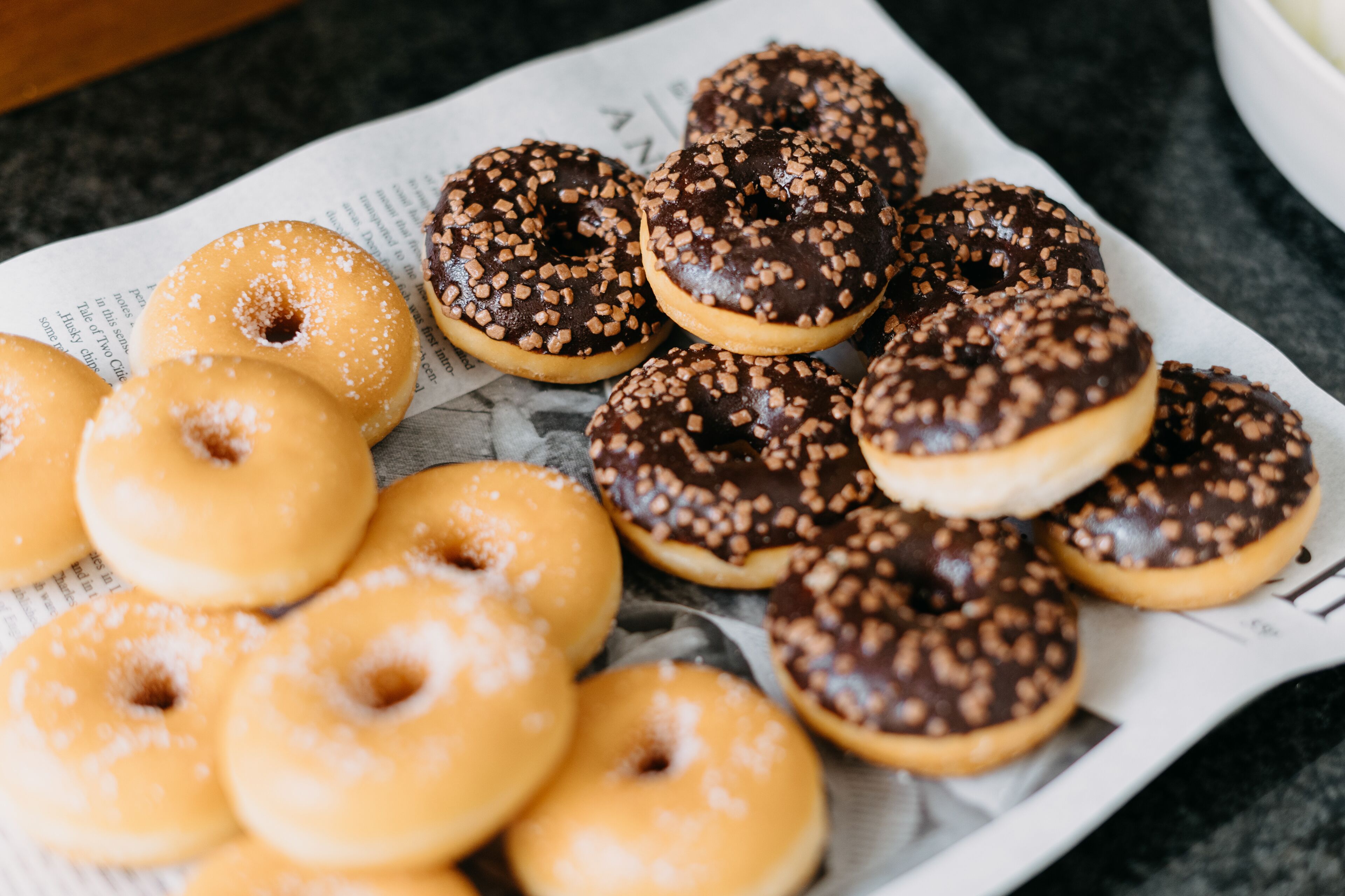 Une assiette remplie de beignets variés, posée sur un journal.