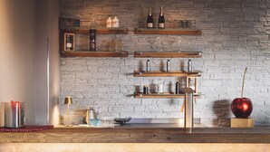A kitchen with wooden shelves, a marble countertop, and a red apple on a wooden block. - Hotel Alte Redaktion Superior (Gevelsberg)