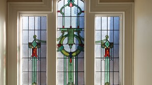 A stained glass window with geometric patterns and a central circular design. - Edgerton Hotel (Huddersfield)
