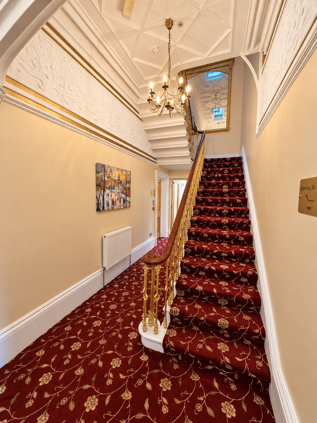 A grand staircase with a red carpet and gold accents, leading to a room labeled 'Rooms 30-40'.
