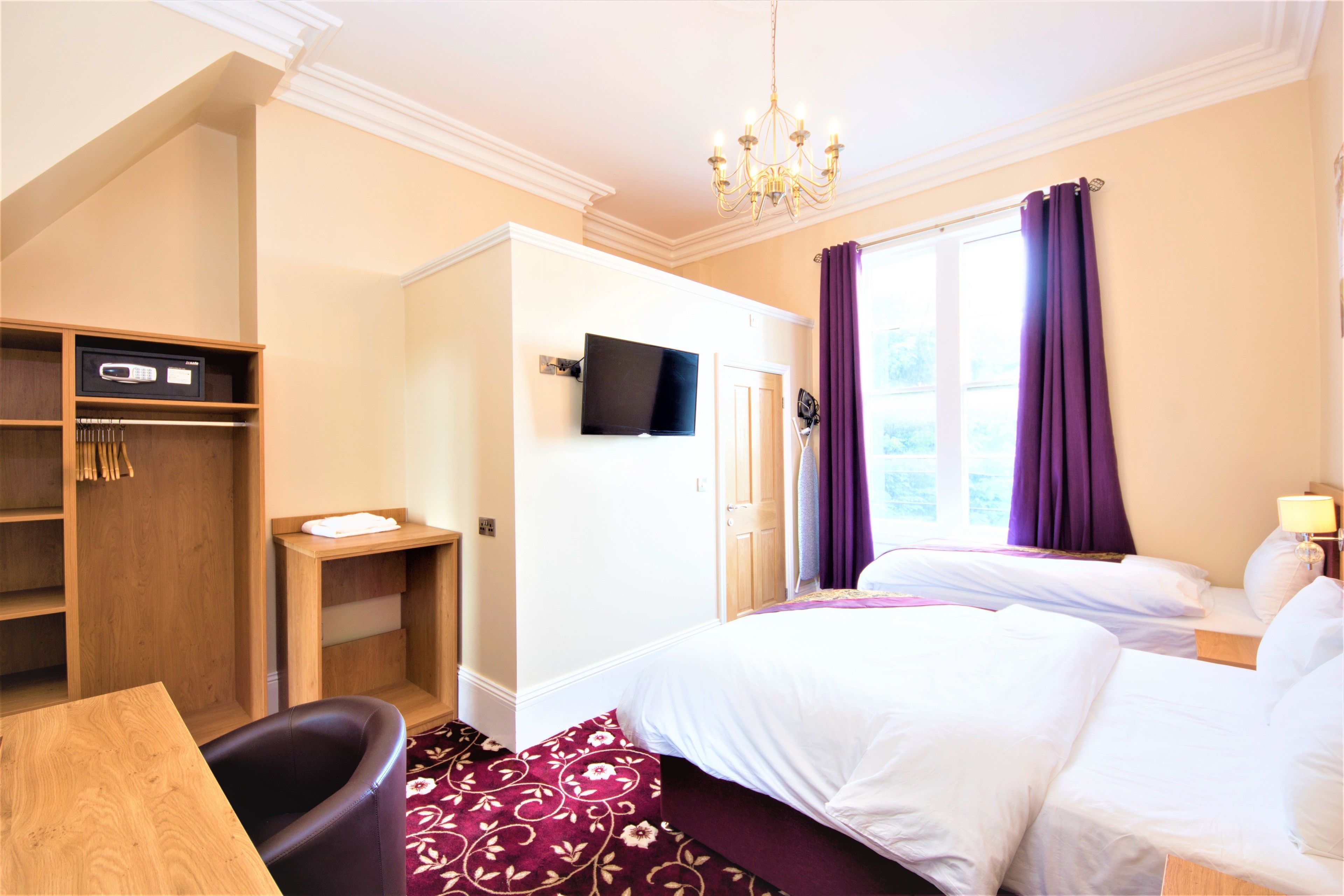 Une chambre d’hôtel équipée d’un lit, d’une télévision, d’un bureau et d’une armoire.