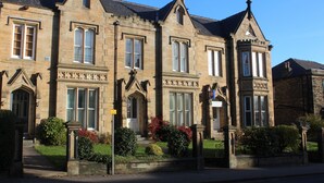A row of traditional stone buildings with large windows and pointed roofs. - Edgerton Hotel (Huddersfield)