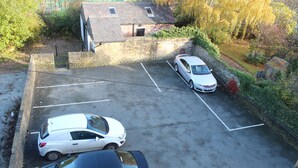 An aerial view of a parking lot with two cars and a building with a sloped roof. - Edgerton Hotel (Huddersfield)