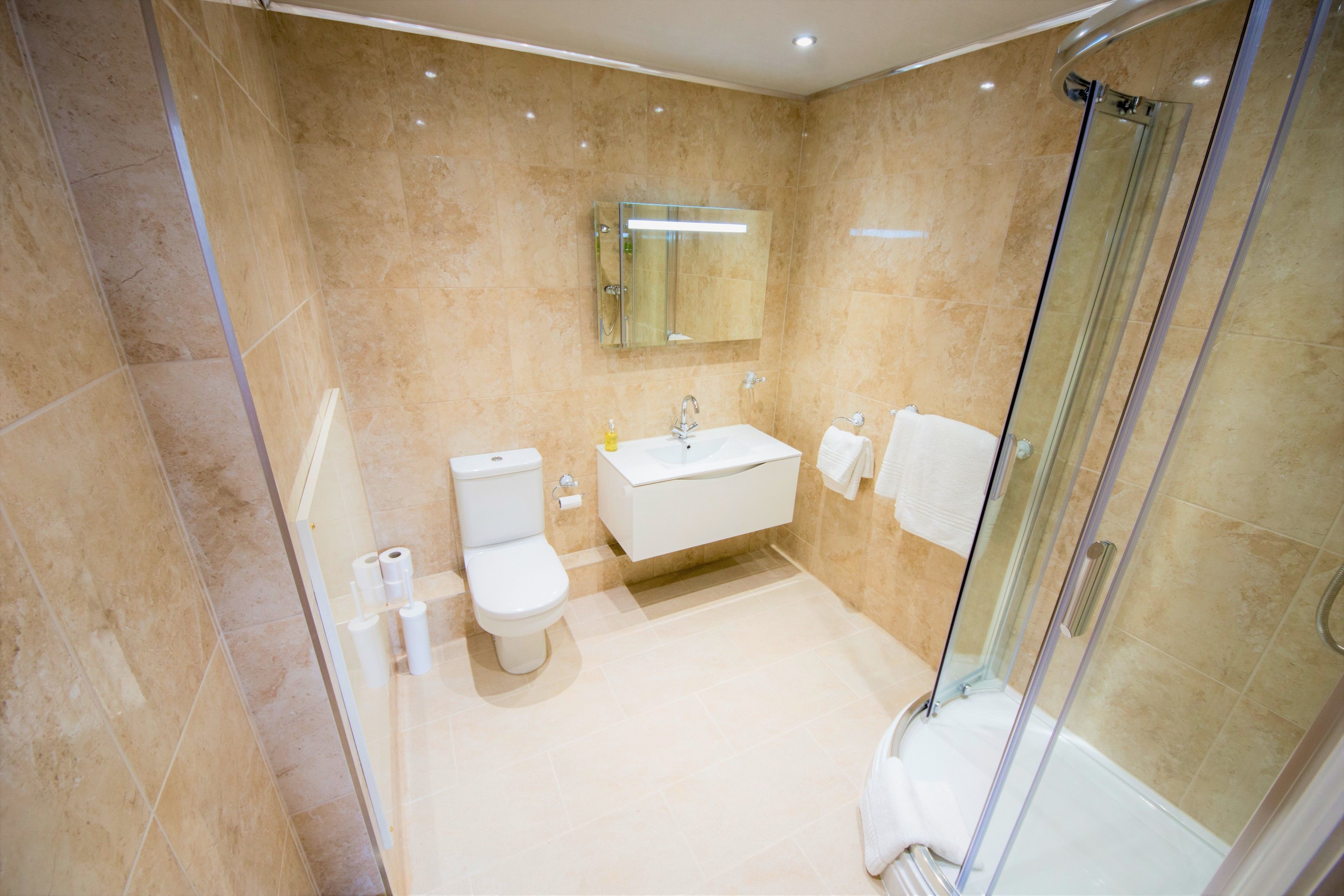 Un bagno moderno con box doccia in vetro, un lavandino bianco e un water.