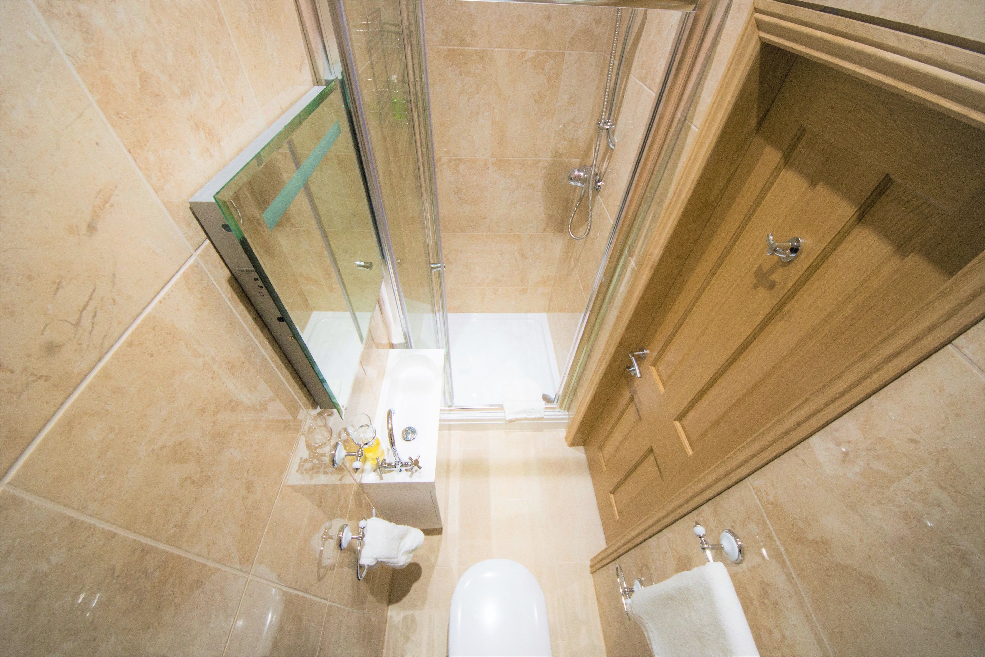 Une salle de bain avec une douche à parois de verre, un lavabo avec un miroir et des toilettes.
