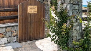 Un arco de piedra que da paso a un portón de madera con un letrero.