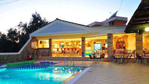 A poolside area with a bar and outdoor seating. - Argiro Village (Rhodes)
