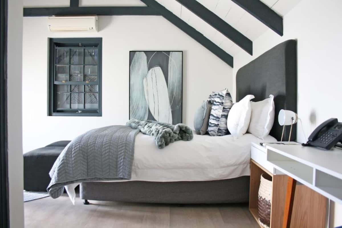 Un dormitorio con una cama, un escritorio, un teléfono y una ventana.