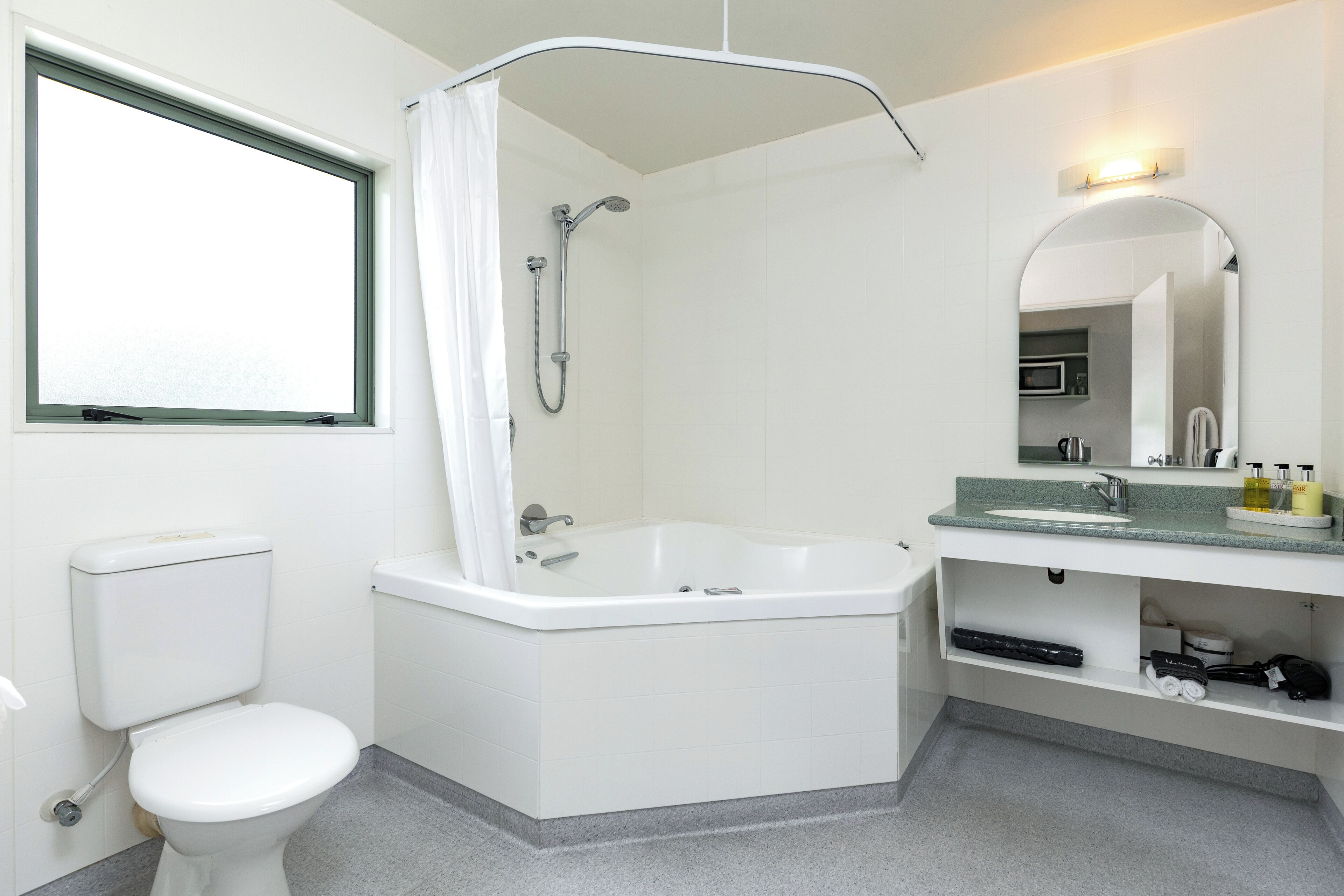 Une salle de bain moderne équipée d’une douche, de toilettes et d’un lavabo.