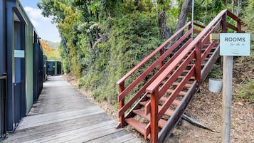 Un sendero de madera que conduce a una escalera con un cartel que indica habitaciones disponibles del 24 al 29.