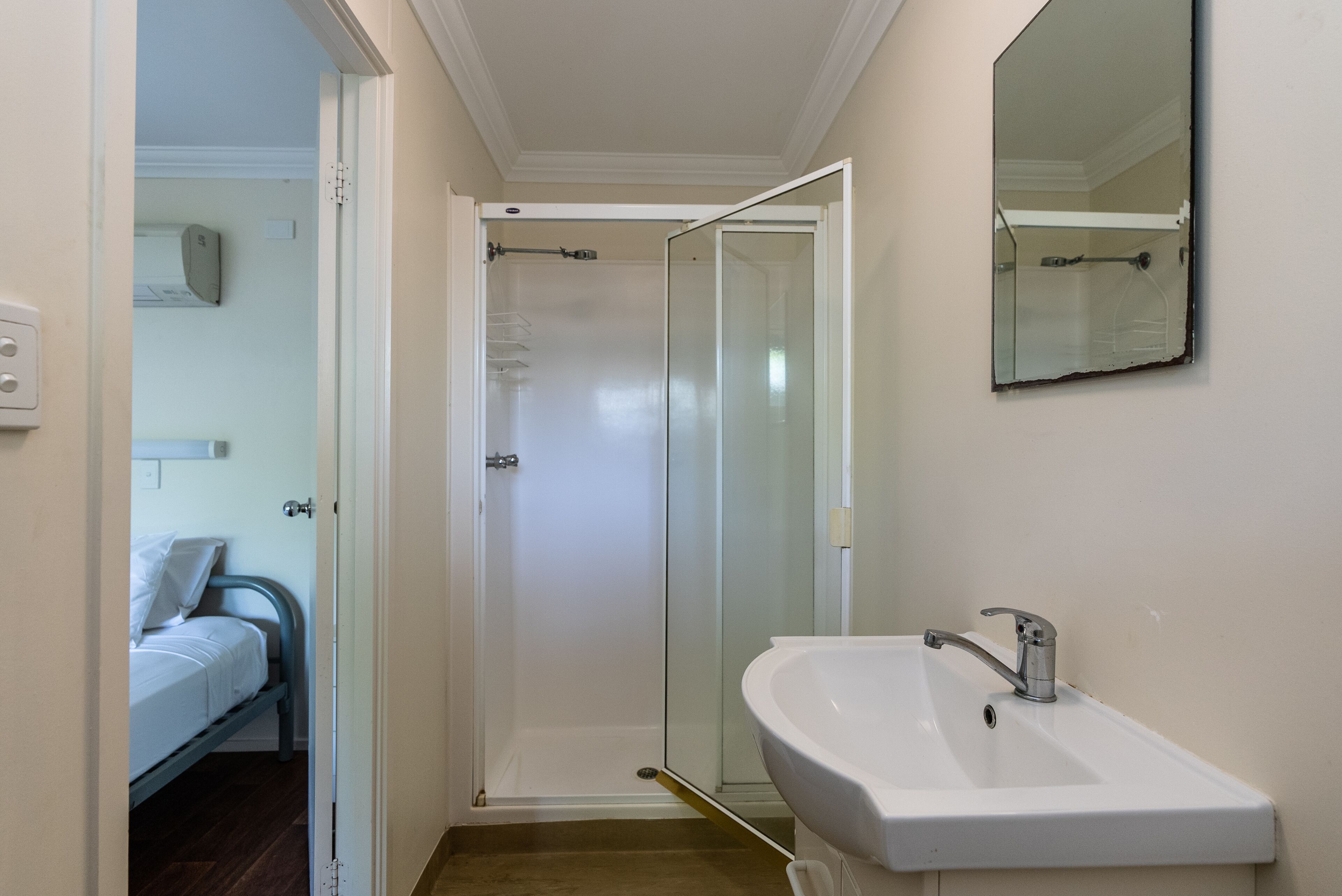 A bathroom with a shower, a sink, and a mirror.