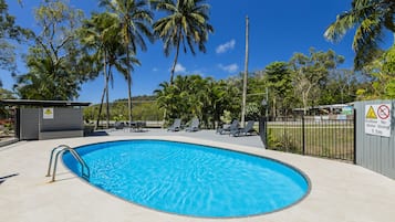 Una piscina al aire libre, sombrillas, tumbonas