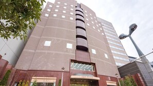 A multi-story building with a curved facade, large windows, and a central entrance with steps. - Sendai Garden Palace (Sendai)