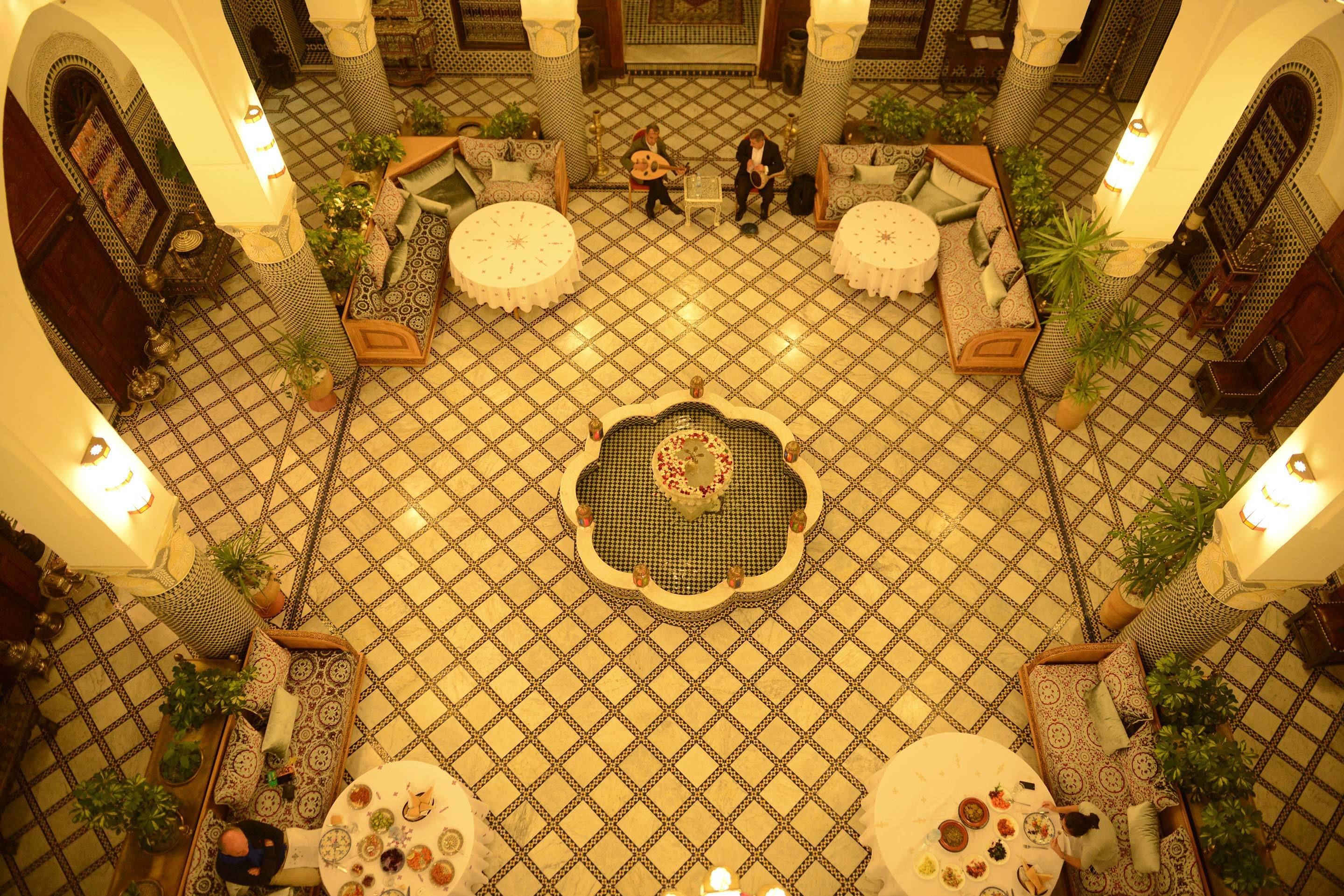 A spacious lobby with a patterned floor, multiple seating areas, and a central decorative table.