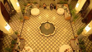 A spacious lobby with a patterned floor, multiple seating areas, and a central decorative table.