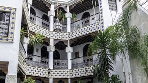 A multi-level courtyard with a pool, featuring ornate tiled balconies and potted plants. - Riad El Yacout (Fes)