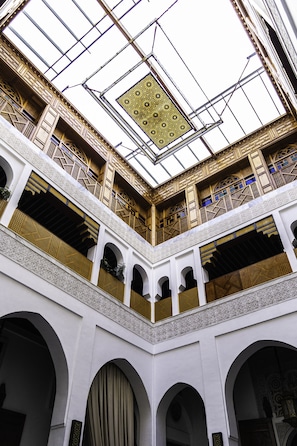 A multi-level interior with arched balconies, a central open space, and intricate ceiling patterns.