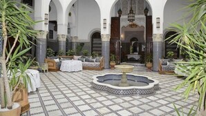 A courtyard with tiled flooring, arches, seating areas, and a central fountain. - Riad El Yacout (Fes)