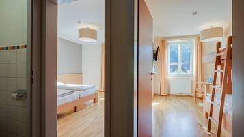 Ein modernes Schlafzimmer mit einem hölzernen Bett, einem Nachttisch und einem Fenster mit Vorhängen.