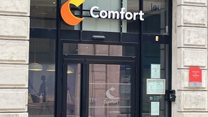 A building entrance with a glass door and a sign that reads "Comfort."
