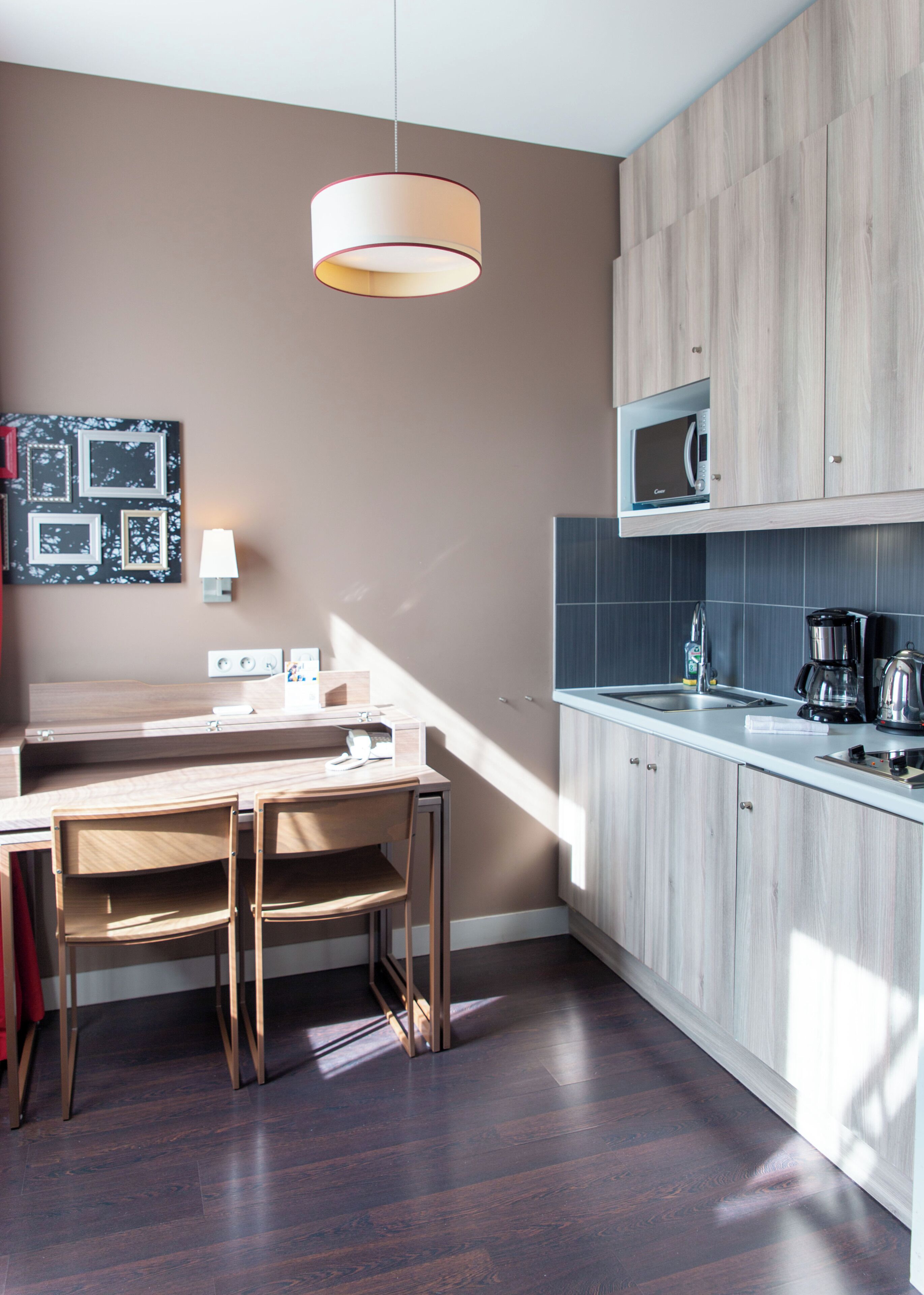 A modern kitchen with a wooden countertop, a built-in microwave, and a coffee maker.