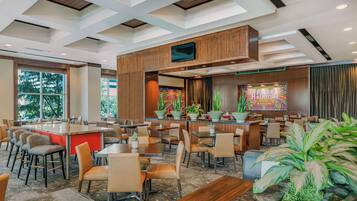 A modern restaurant with a bar area, multiple seating options, and large windows.