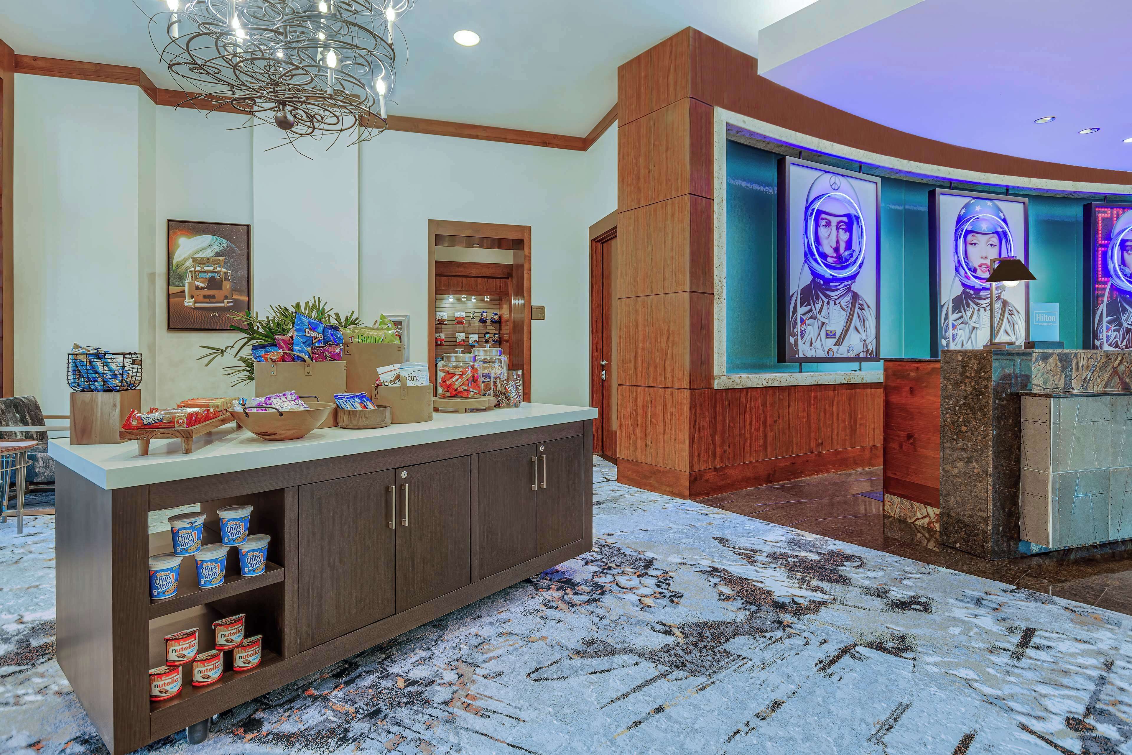 A reception area with a wooden reception desk, a large wall mural, and a patterned carpet.