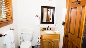 Un baño pequeño con inodoro, lavabo y espejo.
