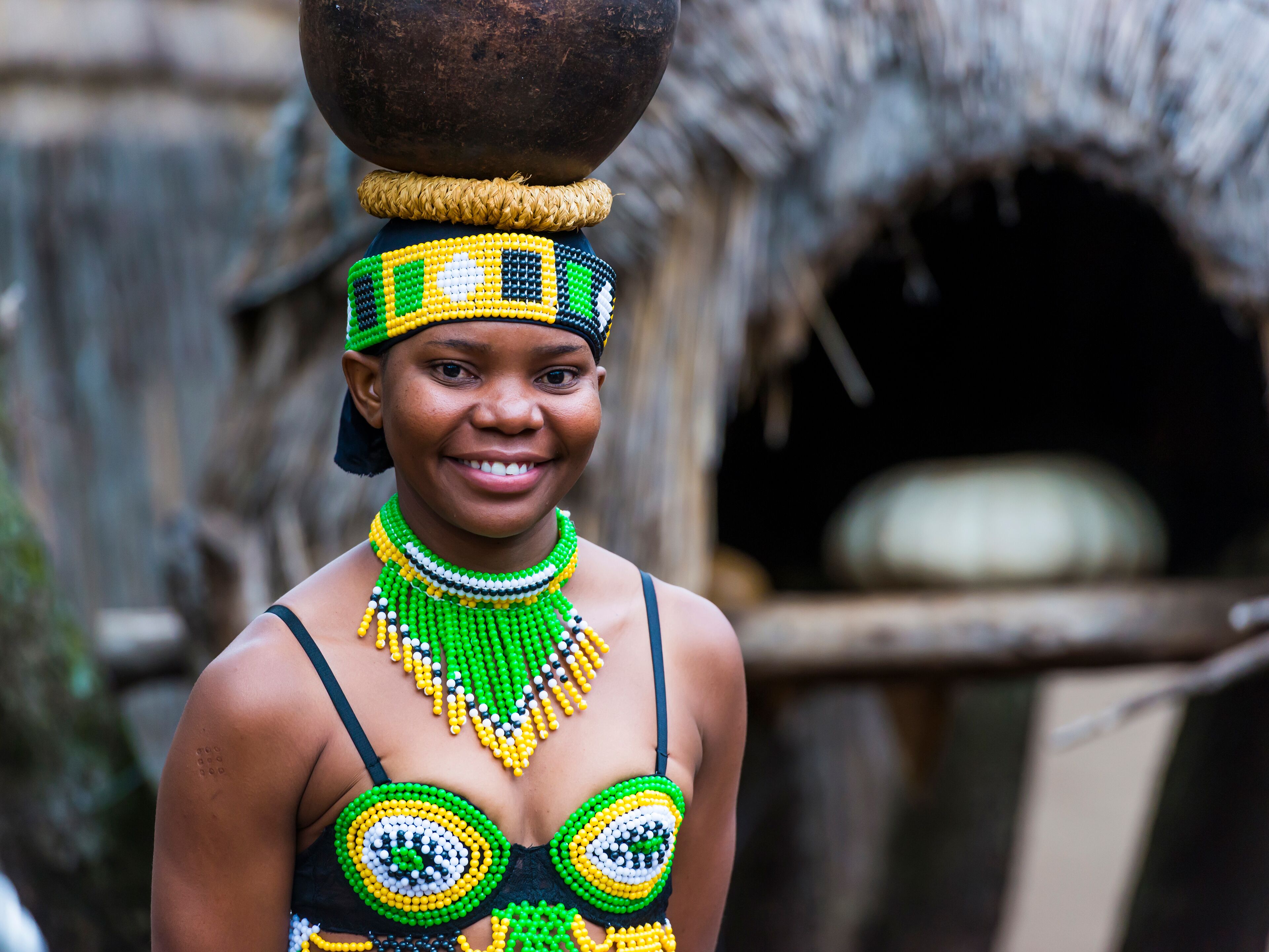 A person wearing traditional attire with a basket on their head.