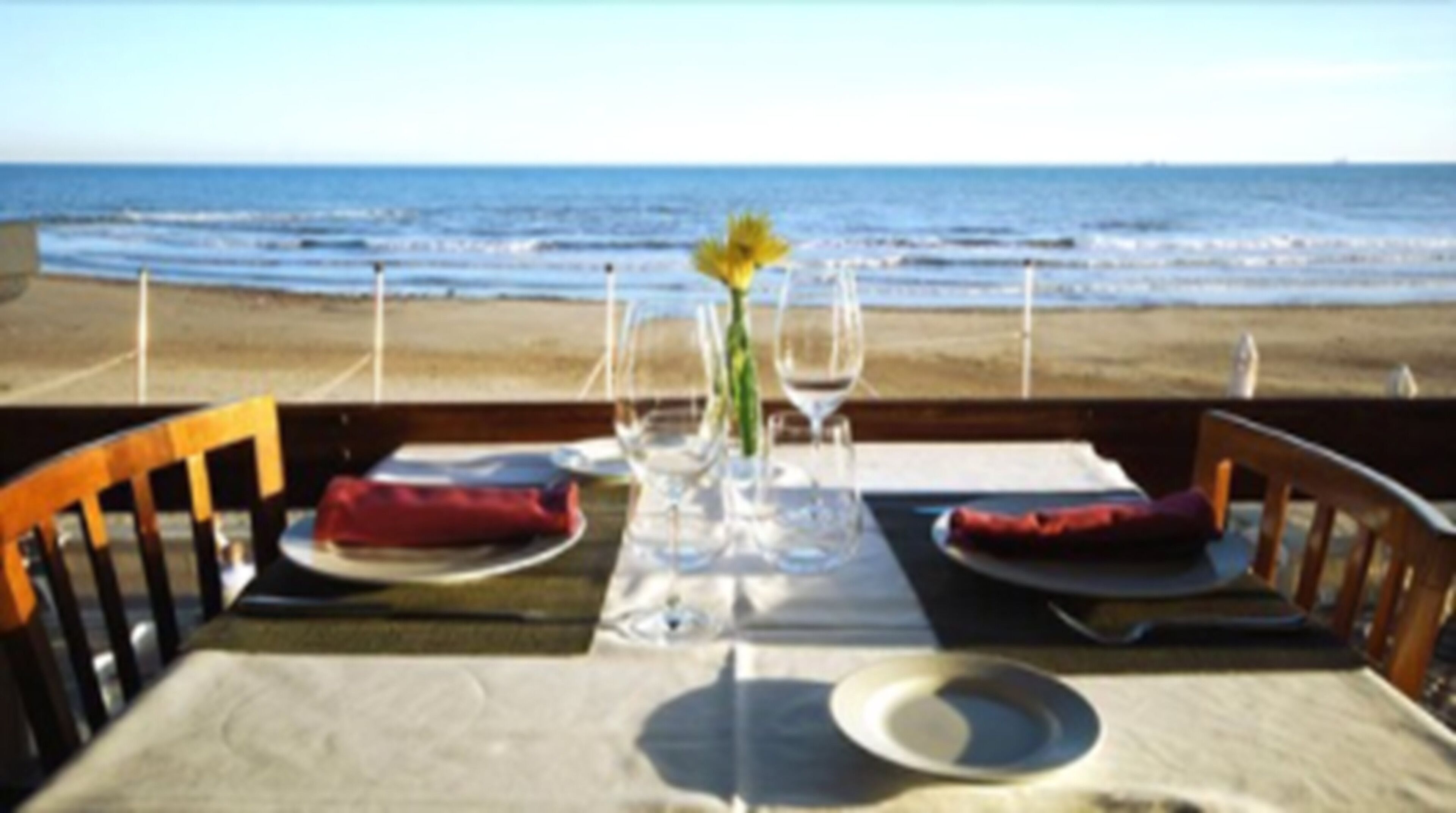A table set for two with a view of the ocean.